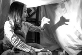 Young Girl Practicing Hand Shadow Puppets