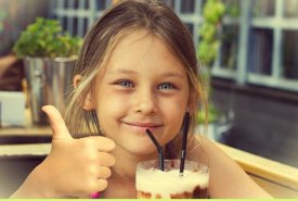 Girl Giving a Thumbs Up to Her Milkshake