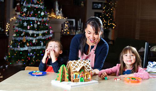 Mom Showing Kids Their Homemade Gingerbread House