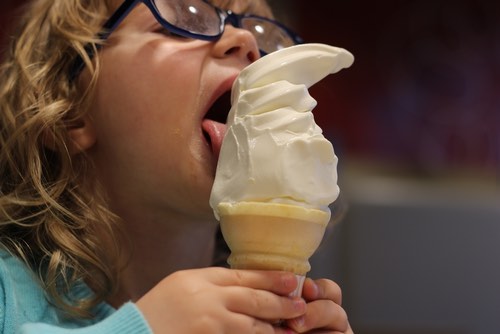 Young Girl Eating a Soft Vanilla Ice Cream Cone